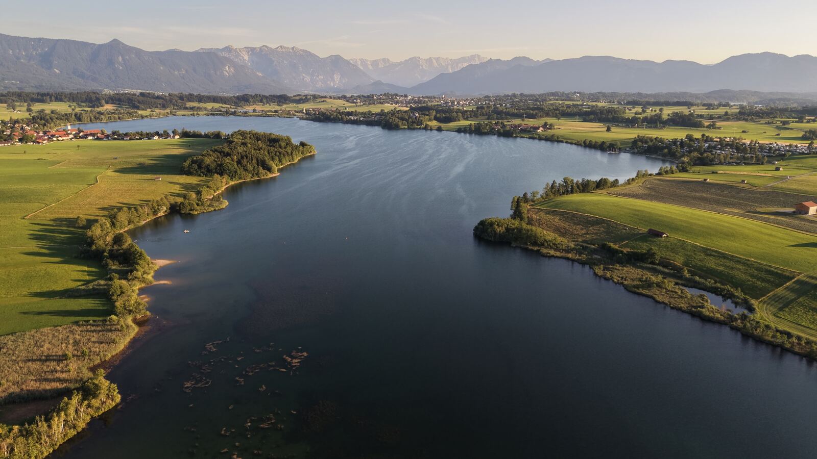 Vogelperspektive auf die Uferlandschaft des Riegsees mit angrenzenden Feldern und Grundstücken